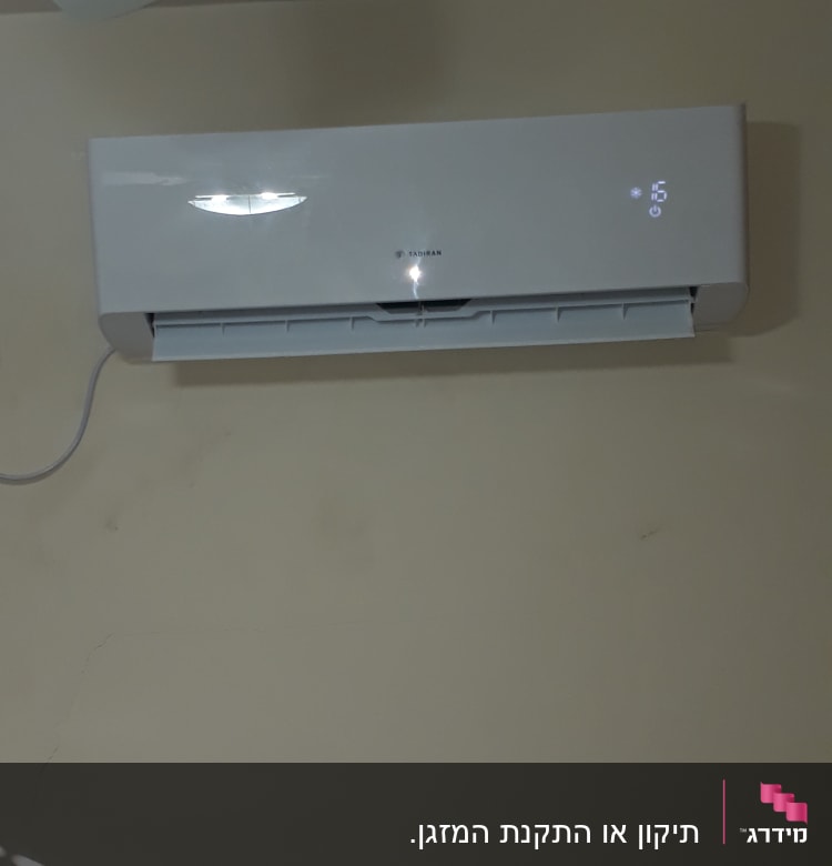 מזגן קיר לבן עם תצוגת טמפרטורה דיגיטלית